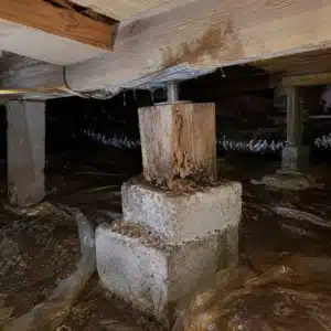 Deteriorated crawl space support post beneath a home causing sticking doors and windows from floor sagging above in Linden, VA.