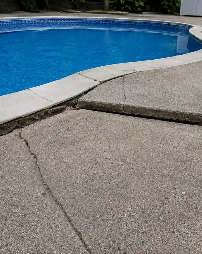 Cracked and sinking concrete pool deck beside a residential swimming pool, VA needing sinking pool deck repair in Winchester, VA.
