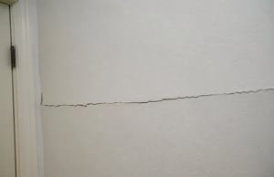 Horizontal crack across an interior drywall indicating lateral foundation pressure a sign of drywall cracks in Berryville, VA.