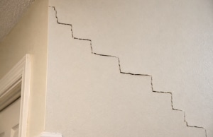Stair-step crack pattern on interior drywall pointing to differential foundation settlement, a sign of drywall cracks in Alexandria, VA.