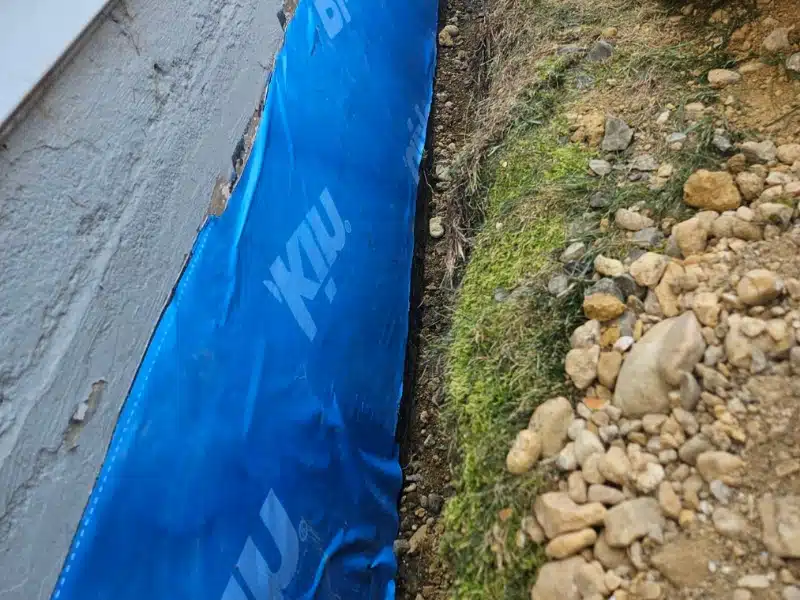 Close-up of the Blueskin membrane bonded directly to the foundation wall in Alexandria VA