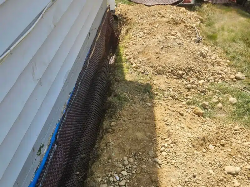 Dimple drainage mat installed over elastomeric waterproofing membrane along foundation wall in Alexandria VA