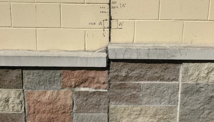 Cracked basement wall in Northern VA, with measurement markings tracking movement, a sign of basement water problem.