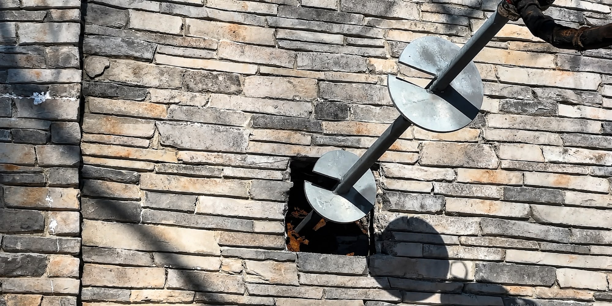 Helical pier installed at a home retaining foundation wall showing helical pier do works in Northern Virginia.
