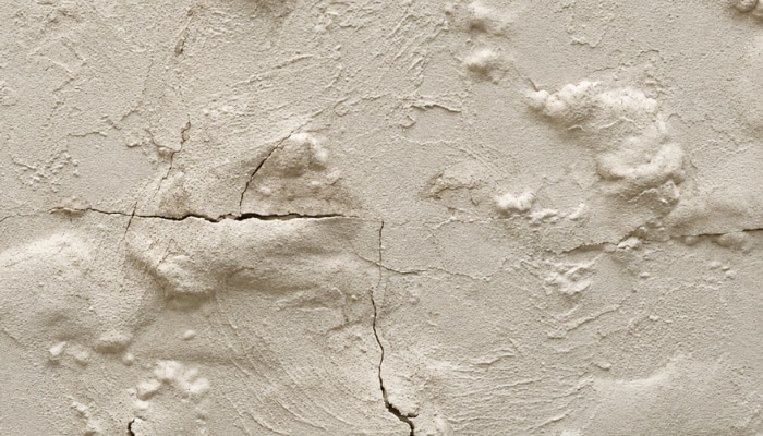Wall surface with bubbling in Northern VA, cracked paint caused by trapped moisture, a sign of basement water problem.