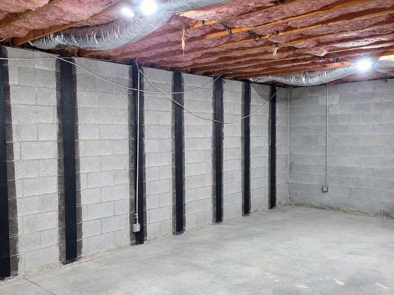 Completed carbon fiber strap reinforcement system on concrete block foundation wall after final inspection in Winchester, VA.