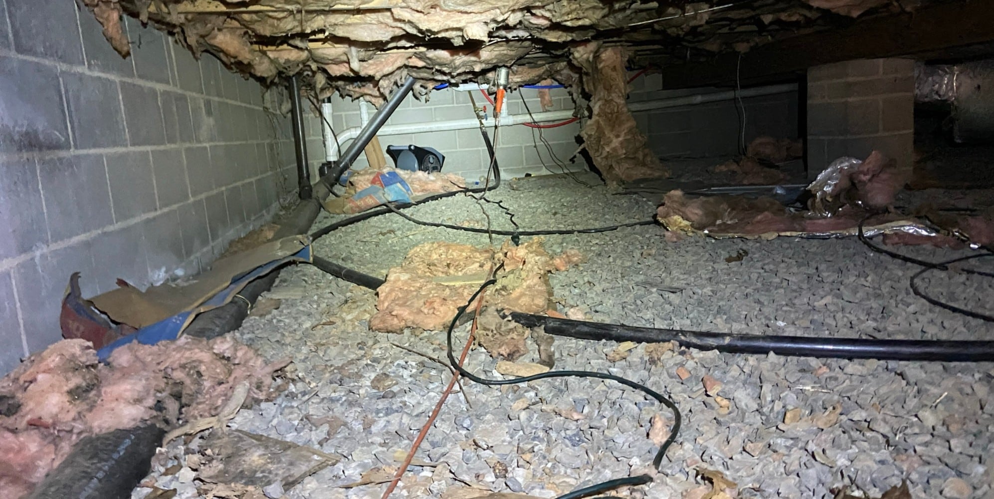 A crawl space with exposed dirt floor, a common sign that needs to install a crawl space vapor barrier in Northern Virginia.