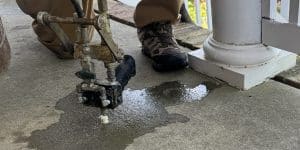 A crew injecting polyurethane foam in a sunken concrete porch to restore surface, a benefit of concrete lifting in Northern Virginia.