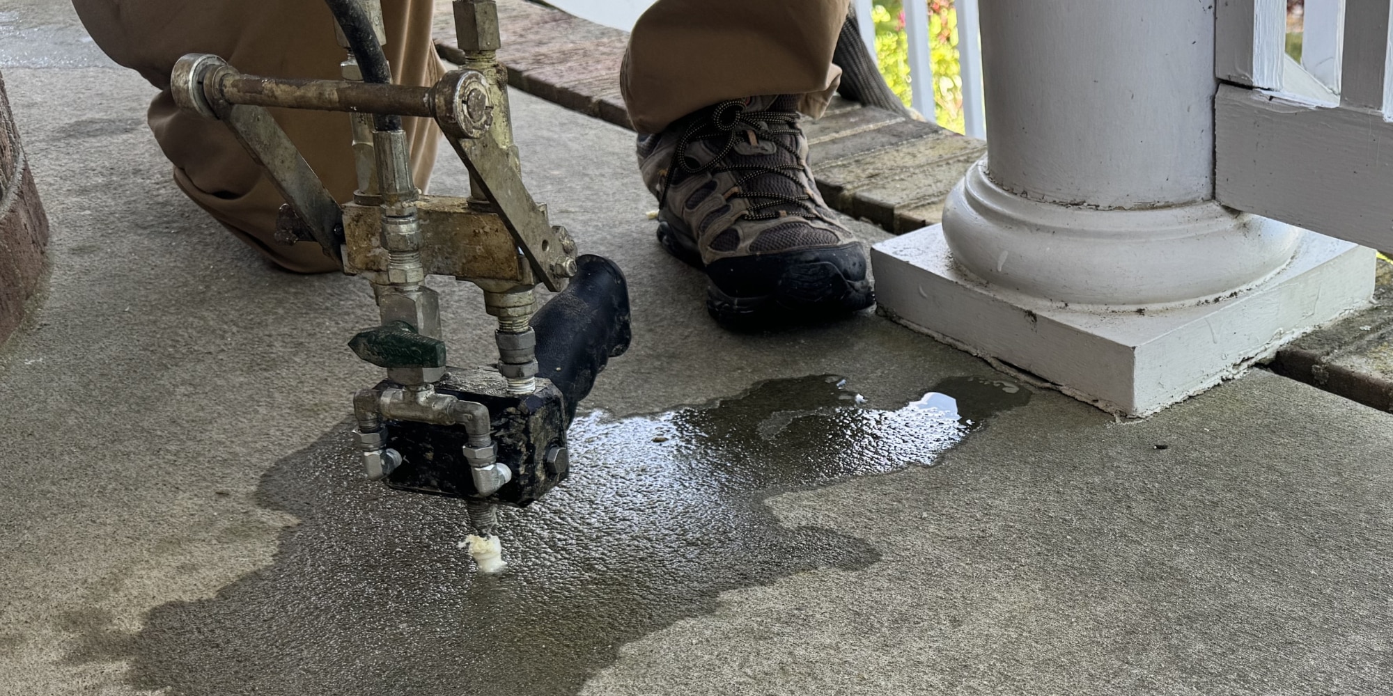 A crew injecting polyurethane foam in a sunken concrete porch to restore surface, a benefit of concrete lifting in Northern Virginia.