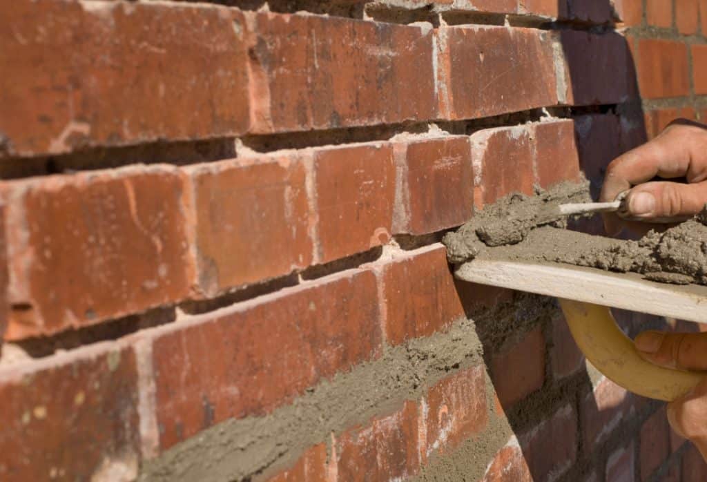 Professional repointing brick mortar joints during a masonry repair in Ashburn, VA.