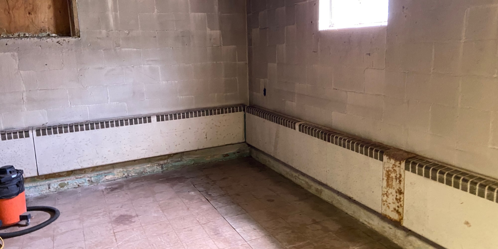 Unfinished basement with moisture stains along foundation walls that needs waterproofing before finishing in Northern Virginia.