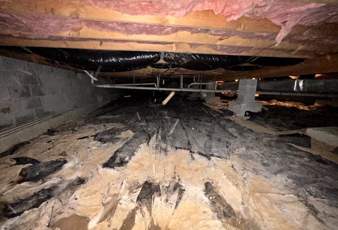 A torn, deteriorating vapor barrier in a crawl space, a clear sign that need a new one is installed in Ashburn, VA.