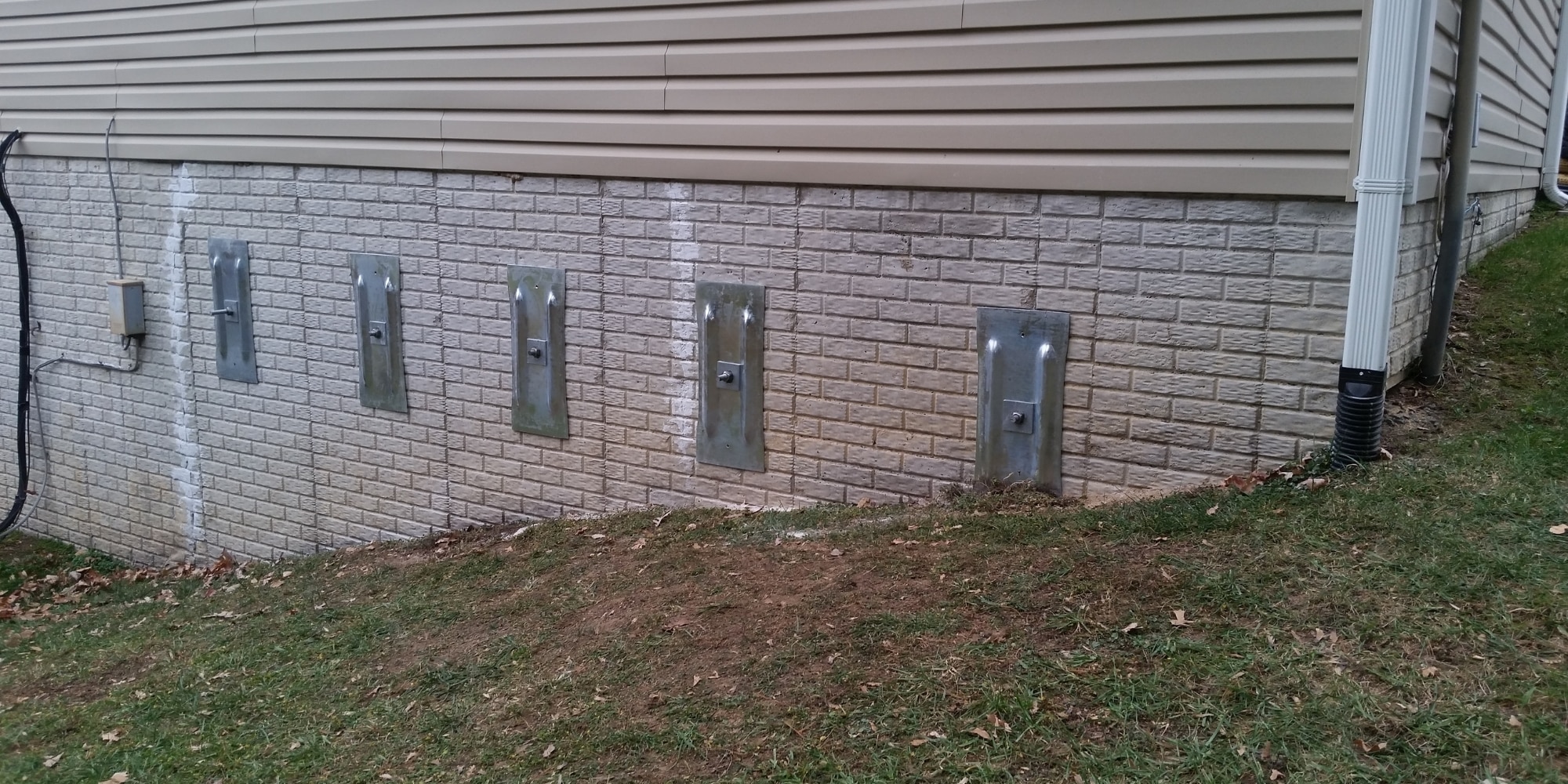 Five installed wall anchor plates stabilizing a foundation wall in Northern Virginia