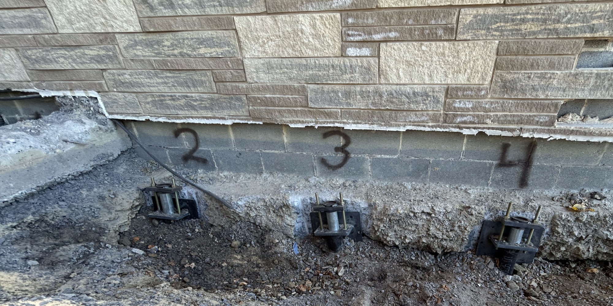 Installed steel push pier stabilizing a foundation footing, showing the benefits of push piers for foundation repair in Northern, VA.
