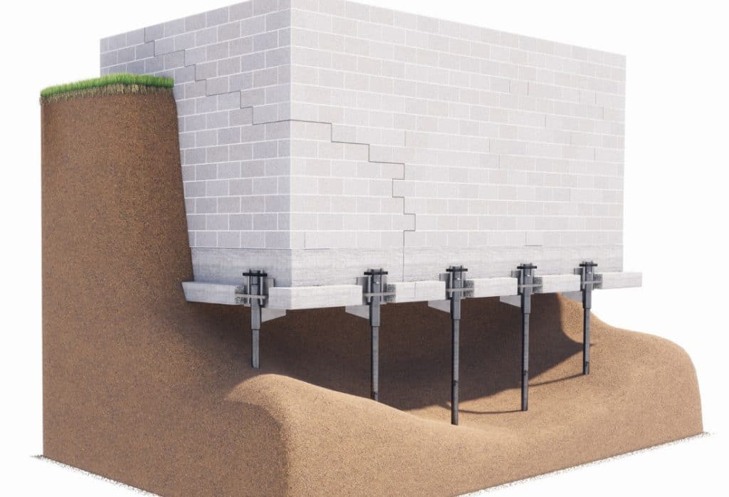 Diagram of steel push piers supporting a cracked block foundation, one of the benefits of push piers for a settled home in Ashburn, VA.