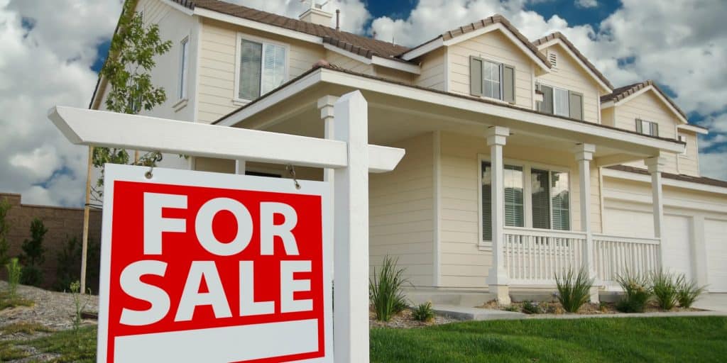 A home with a for sale sign, illustrating how a waterproofed basement can increase home value before selling in Northern, VA.
