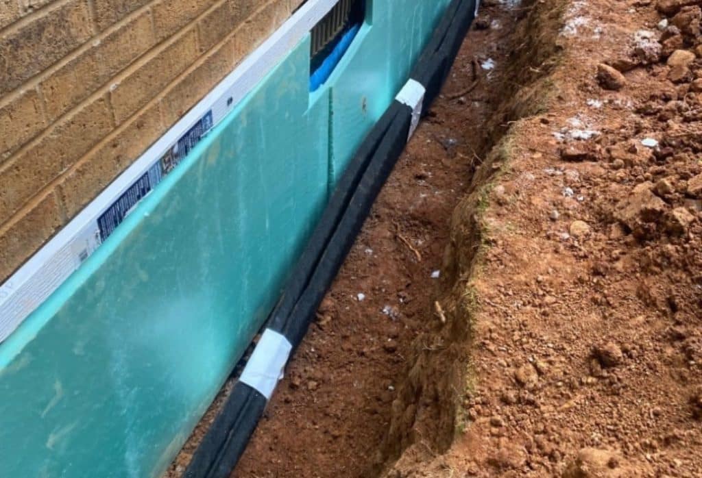 Exterior foundation wall excavated with waterproof membrane applied, factors for for basement waterproofing cost in Winchester, VA