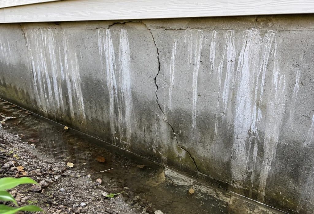 Vertical foundation crack with heavy mineral staining where water has been seeping through into the basement in Alexandria, VA.