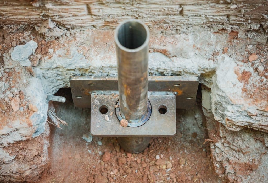 Steel push pier brackets in a narrow excavation, showing the benefits of push piers in tight spaces in Winchester, VA.