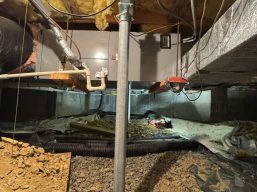 Adjustable steel support posts installation during sagging floor repair in Front Royal, VA, to lift and stabilize the floor.