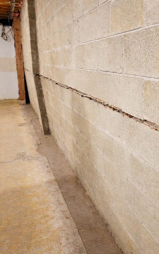 Concrete block wall bowing inward with visible horizontal crack showing what a bowing foundation wall looks like in Winchester, VA.
